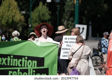 Vancouver, BC, Canada - July 24, 2021:  Activist chants while holding a banner at an "Extinction Rebellion" climate change protest in front of the Burrard Street Bridge