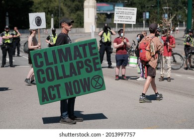 Vancouver, BC, Canada - July 24, 2021:  Activist holds a sign at an "Extinction Rebellion" climate change protest in front of the Burrard Street Bridge