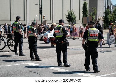 Vancouver, BC, Canada - July 24, 2021:  Vancouver Police officers contain the crowd at an "Extinction Rebellion" climate change protest in front of the Burrard Street Bridge