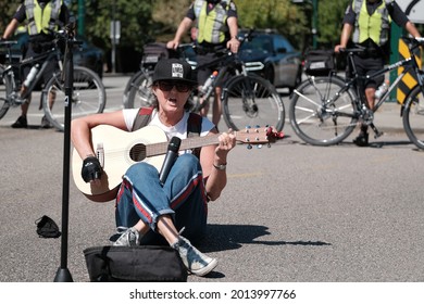 Vancouver, BC, Canada - July 24, 2021:  Activist plays the guitar at an "Extinction Rebellion" climate change protest in front of the Burrard Street Bridge