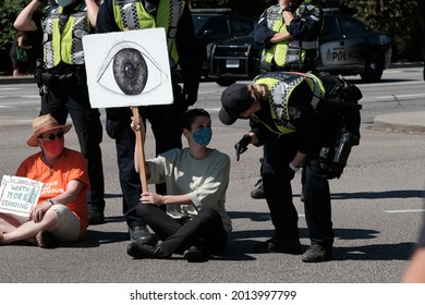 Vancouver, BC, Canada - July 24, 2021:  Vancouver Police officers prepare to arrest activists at an "Extinction Rebellion" climate change protest in front of the Burrard Street Bridge