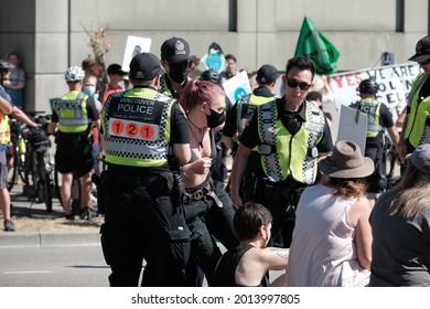 Vancouver, BC, Canada - July 24, 2021:  Vancouver Police officers arrest an activist at an "Extinction Rebellion" climate change protest in front of the Burrard Street Bridge