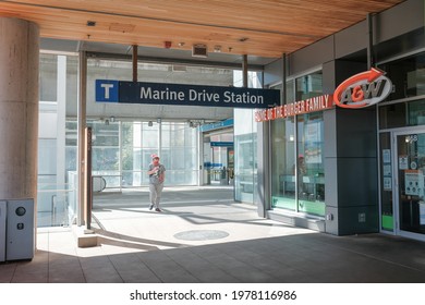 Vancouver, BC, Canada - May 22, 2021: Man walks out from the gates at the Marine Gateway-Marine Drive Skytrain Station