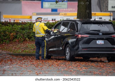 Vancouver BC Canada October 2021: Police Officer Gave A Ticket To A Distracted Driving Driver In A Black Mini Van. 