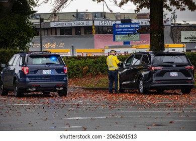 Vancouver BC Canada October 2021: Police Officer Pull Over A Black Mini Van In Parking Lots And Give A Distracted Driving Ticket To  Driver In A Black Mini Van. 