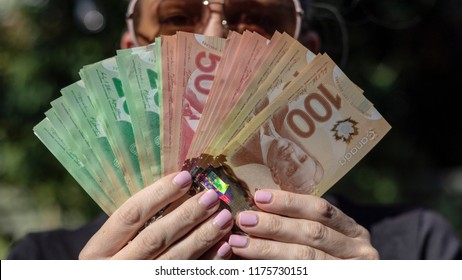 Vancouver, BC / Canada - September 8th 2018 : A Woman Fanning Out Canadian Cash