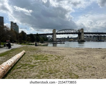 Vancouver, British Columbia, Canada - April 25, 2022: People playing on Sunset Beach near Burrard Bridge. The popular seawall along False Creek. 