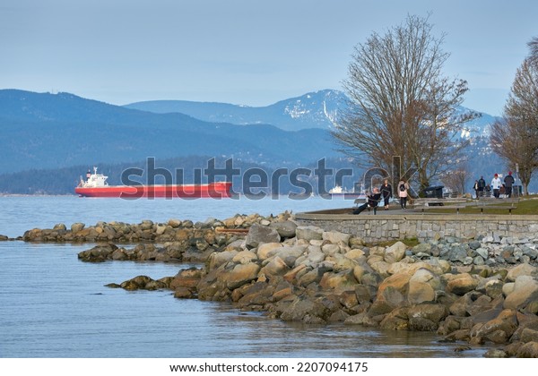 Vancouver, British Columbia, Canada – March 16, 2019.\
English Bay Seawall Vancouver. People stroll and relax on the\
English Bay seawall in downtown Vancouver. British Columbia,\
Canada.\
\
             \
