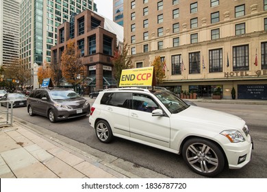 Vancouver, British Columbia, Canada, October 18th, 2020, A White Car With The Anti Communism Movement Sign On The Top, In Downtown Vancouver.