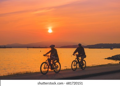 Vancouver British Columbia,July 17,2017.family Biking At Beach With Sunset Backgrounds