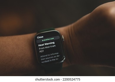 Vancouver, Canada - August 14, 2022: Woman Is Looking At The Smart Watch With Message Heat Warning On Display