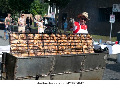 VANCOUVER, CANADA - JUNE 09, 2014: Italian Day In Commercial Drive.Crowd Of People Walking. Man Cooking Chicken On Barbecue Grill Street.