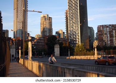 VANCOUVER, CANADA - Mar 07, 2021: A young woman riding a bike on Burrard Bridge in Vancouver, British Columbia, Canada