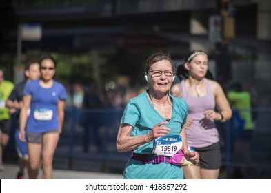 Vancouver, Canada - May 1, 2016: An Unidentified Older Woman Running In The BMO Vancouver Marathon Runs Up The Final Hill Towards The Finish Line. 