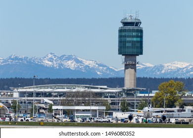 VANCOUVER, CANADA - May 10, 2019: Air Traffic Control Tower At Vancouver Intl. Airport (YVR) Seen With Snow Covered Mountains In The Background.