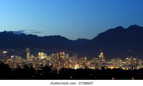 Vancouver Canada At Night Set In Between The Trees And The North Shore Mountains.