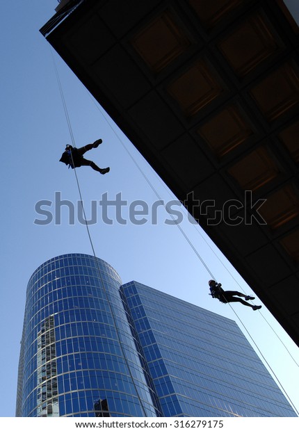 VANCOUVER, CANADA - SEPTEMBER 10, 2014: A man\
climbs down office building during Easter Seals Drop Zone\
fundraiser to benefit children with disabilities in Vancouver,\
Canada, on September 10,\
2014.
