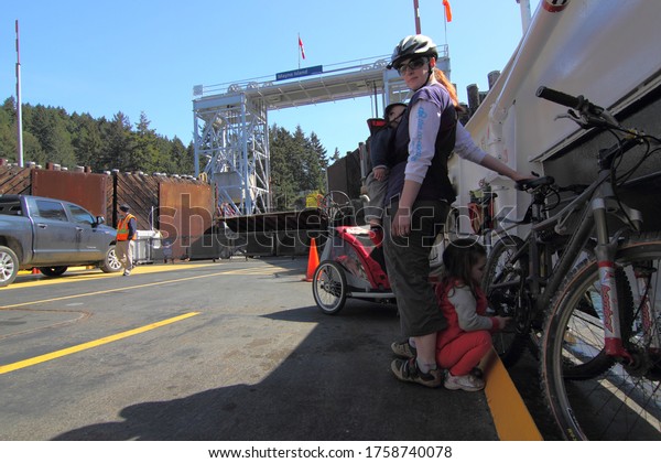 Vancouver Island, British\
Columbia Canada, June 3, 2020: BC Ferries carry a family with\
vehicles as they venture on a cycling trip through the West Coast\
gulf islands.