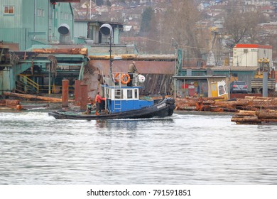 VANCOUVER - January 10, 2018: A Tug Boat Crew Works On Vancouver, Canada's Fraser River Sorting Logs For Processing On A Small Tug Boat On January 10, 2018.