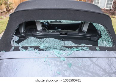 Vandalized Soft Top Convertible Sports Car With Back Window Smashed Out And Glass Laying Everywhere - Close Up