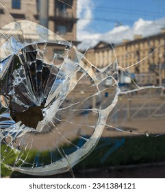 Vandalized window of building, smashed broken glass. A broken glass shop window. Broken glass front door.Broken window destruction, glass shards, accident.