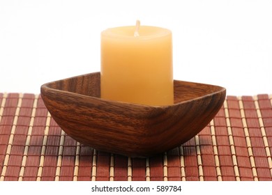 A Vanilla Candle In An Exotic Holder Made Of Wood.