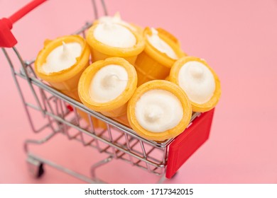 Vanilla Cream In Wafer Cup In A Shopping Cart A Small Toy. Vanilla Ice Cream Cone On Pink Color Background. Candy Bar And Cake Pops. Holiday Treats. Sweet Tooth. Candy Shop. 