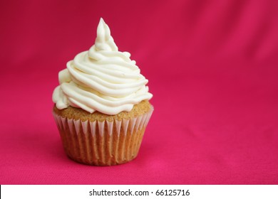 Vanilla Cup Cake With White Icing On Red Background