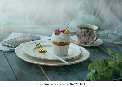 Vanilla Cupcake With Fruits, A Hot Cup Of Tea And A Mobile Phone Near The Window, On The Background Of A Wooden Table, Top View, Copy Space. Seasonal, Morning Sunday Breakfast And Rest.

