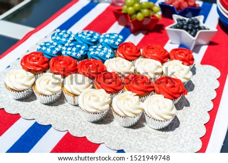 Vanilla cupcakes with red, blue, and white icing shaped in an American flag.