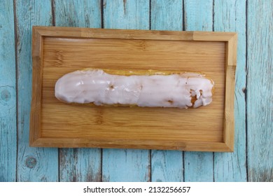 Vanilla Eclair On A Wooden Plate