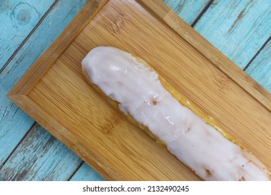 Vanilla Eclair On A Wooden Plate