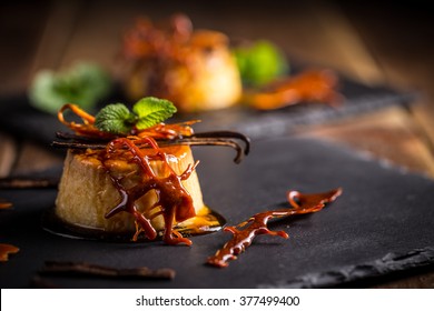 Vanilla flan dessert served on black slate - Shutterstock ID 377499400