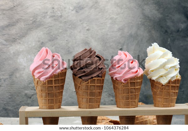 Vanilla frozen\
yogurt or soft ice cream in waffle cone and strawberry, raspberry\
and chocolate softice\
cream