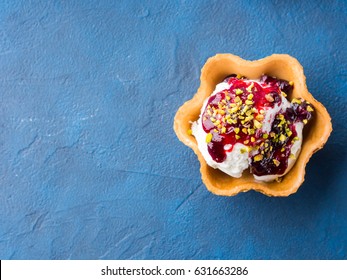 Vanilla Home Made Ice Cream Scoops In Waffle Cup With Berry Sauce And Pistachio Nuts. Sweet Treat