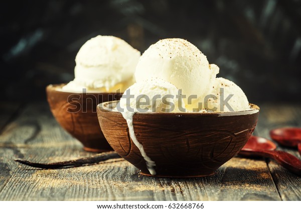 Vanilla ice cream balls, brown bowls, dark\
background, selective\
focus