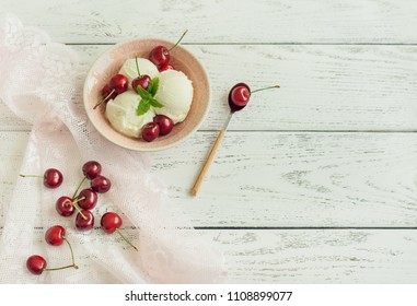 Vanilla-Eis mit Kirschen auf 
 weißer Holzhintergrund.