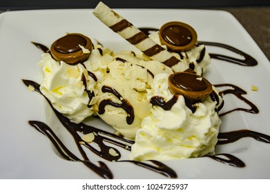 Vanilla icecream with whipped cream waffle stick and toffifee (germam sweets).