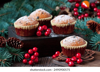 Vanilla muffins on  wooden rustic backgrond wiht Christmas tree twigs decorated with red berries.  Winter  holidays background - Powered by Shutterstock