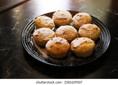 vanilla muffins with powdered sugar on a plate close-up. sweet pastries