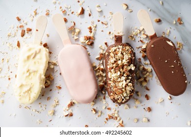 vanilla popsicles coat with chocolate and top with almond lined on white background.