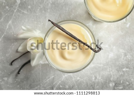 Vanilla pudding, sticks and flower on light background
