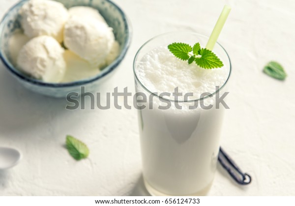 Vanilla Shake with Ice Cream and Mint on white\
background. Vanilla Ice Cream Milk Shake. Banana Smoothie with Mint\
and Vanilla.