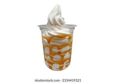Vanilla soft serve ice cream with caramel syrup in a clear plastic cup isolated on white background with clipping path and copy space. Frozen yogurt vanilla caramel sundae cold dessert.