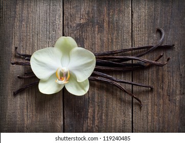 Vanilla sticks, vanilla flower, vanilla pod on the wood background.