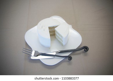 Vanilla Tasting Cake Slice Isolated On Plate With Fork And Knife