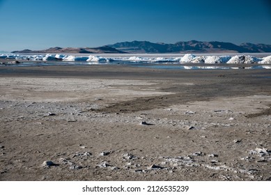 The vanishing Great Salt Lake with salt mounds in the near distance.  Due to drought and poor irrigation practices this iconic lake is disappearing. - Shutterstock ID 2126535239