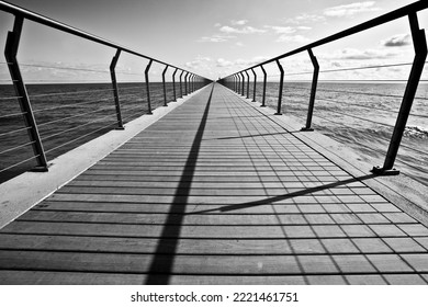 Vanishing Point Of A Bridge Entering The Sea With Symmetrical Lines And Rhythm