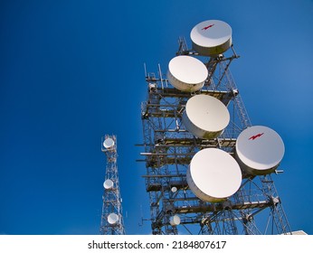 Vanlop, UK - May 19 2022: Microwave Communication Dishes On A Tower On The Hill Of The Ward Of Scousburgh In Southern Shetland, UK. Taken On A Sunny Day With A Clear Blue Sky.