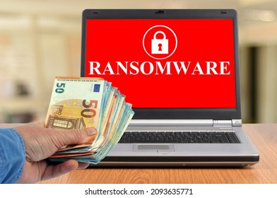 
Vannes, France, December 19, 2021: Ransomware Payment Concept With A Wad Of Banknotes And A Laptop